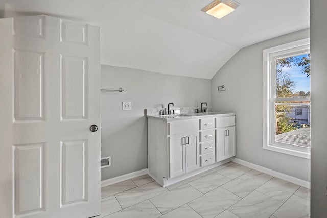 bathroom with vanity and lofted ceiling