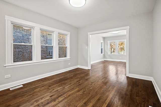 empty room with dark hardwood / wood-style flooring