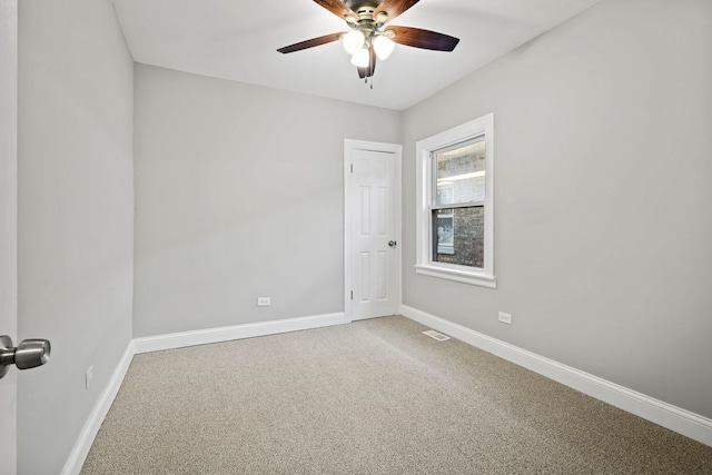 empty room featuring ceiling fan and carpet