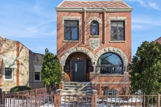 view of front facade with a tiled roof and brick siding