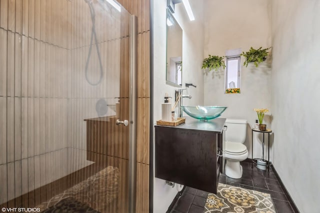 bathroom with a stall shower, vanity, toilet, and tile patterned floors