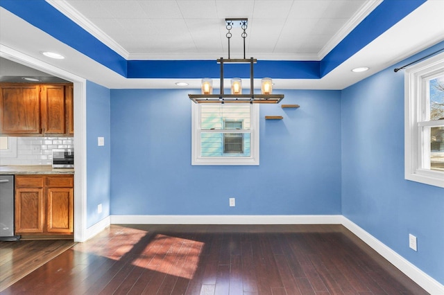 unfurnished dining area with a raised ceiling, ornamental molding, and a chandelier