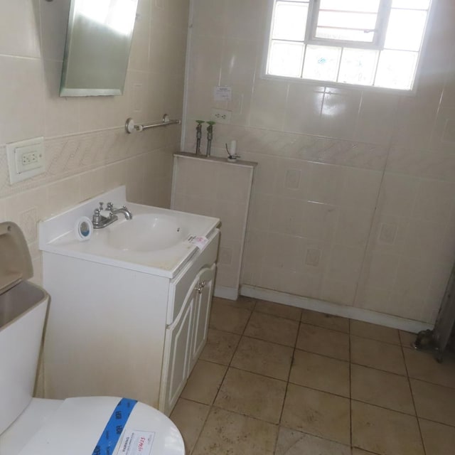 bathroom with tile patterned flooring, vanity, tile walls, and toilet