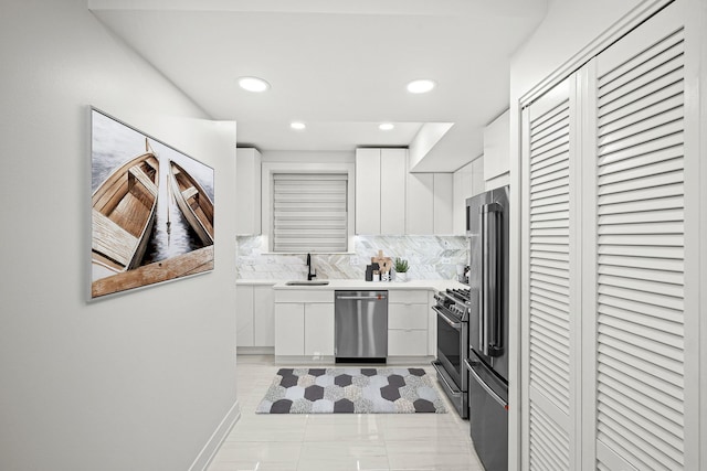 kitchen featuring white cabinetry, appliances with stainless steel finishes, sink, and backsplash