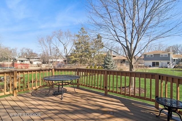 deck featuring a residential view, a trampoline, and a lawn