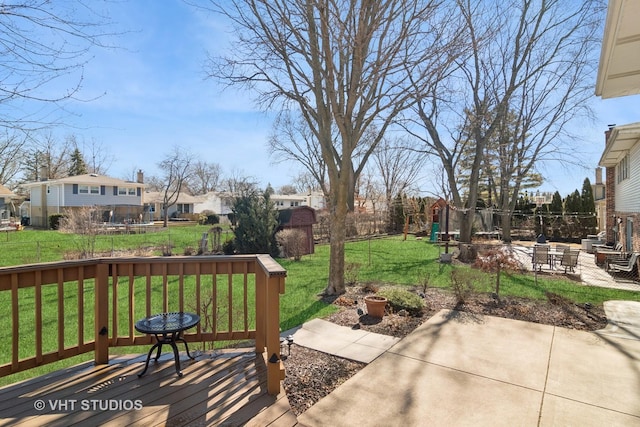 view of patio / terrace featuring an outbuilding, a residential view, a wooden deck, and fence