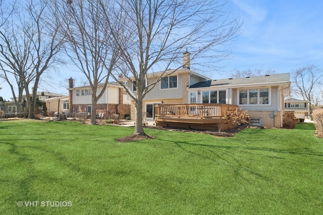 rear view of house with a lawn and a deck