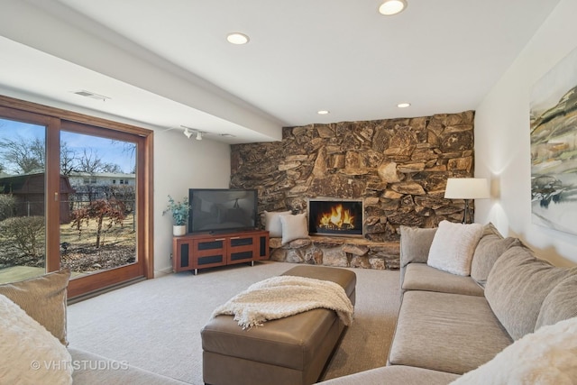 carpeted living area featuring visible vents, recessed lighting, and a fireplace