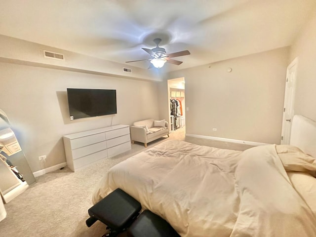 carpeted bedroom with ceiling fan, a walk in closet, and a closet