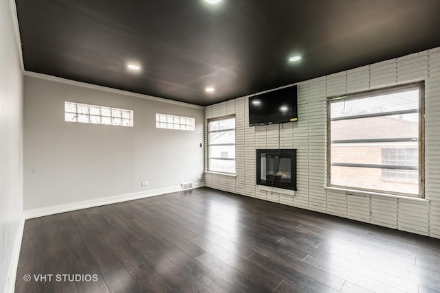 unfurnished living room featuring dark hardwood / wood-style flooring and a brick fireplace