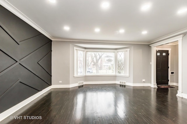 unfurnished living room with wood-type flooring and ornamental molding