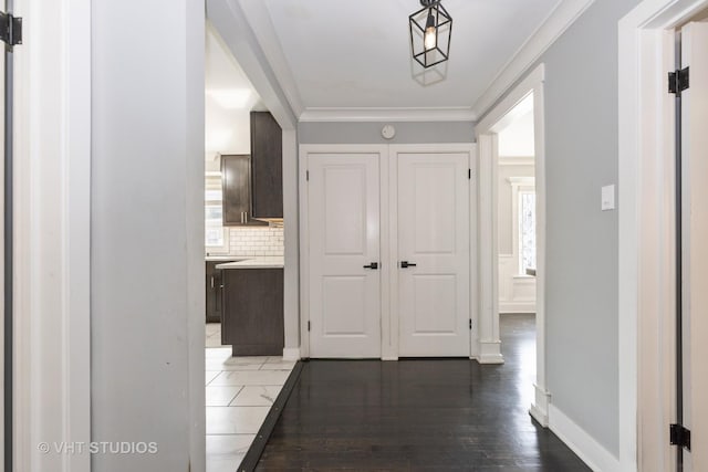 corridor with dark wood-type flooring and ornamental molding