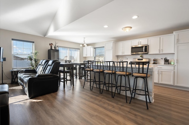 kitchen featuring white cabinetry, hanging light fixtures, stainless steel appliances, and plenty of natural light