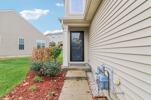 view of exterior entry with a lawn