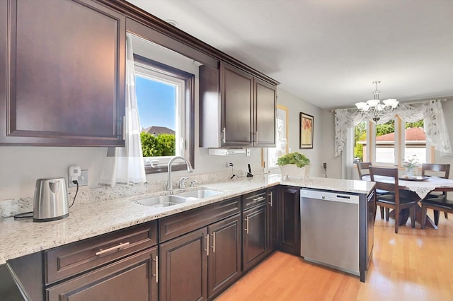 kitchen featuring sink, pendant lighting, light hardwood / wood-style flooring, a notable chandelier, and dishwasher