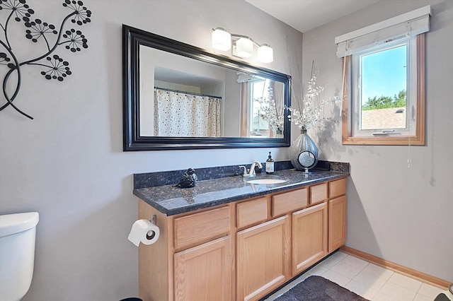 bathroom featuring tile patterned flooring, vanity, and toilet