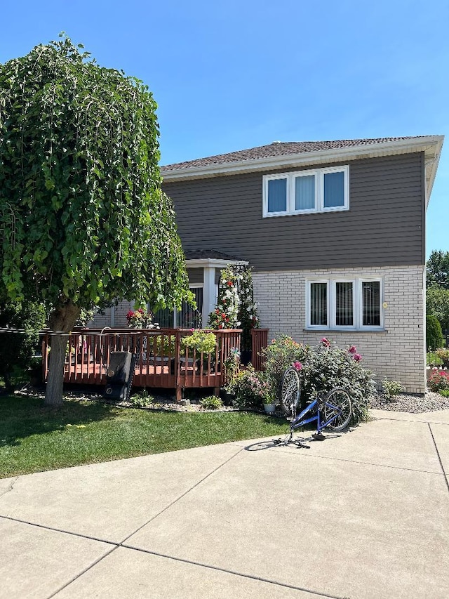 back of property featuring a yard and a wooden deck