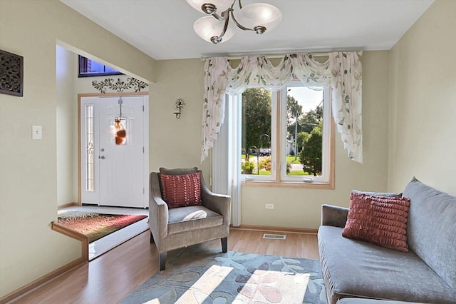 living area featuring light hardwood / wood-style flooring and a chandelier