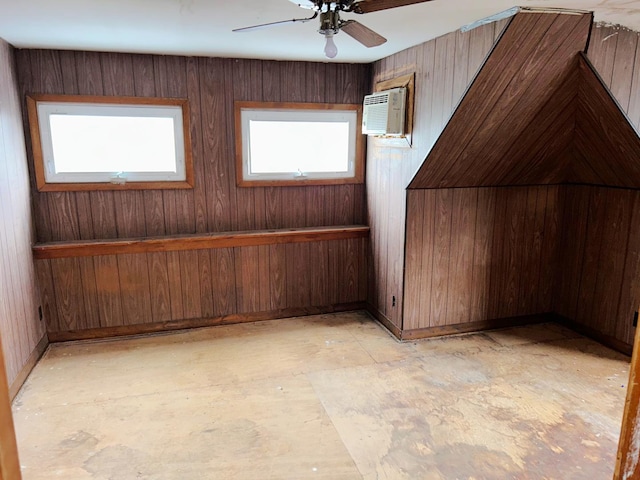 additional living space featuring wood walls, ceiling fan, and a wall mounted air conditioner