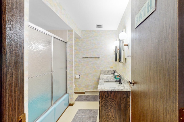 bathroom with vanity and bath / shower combo with glass door