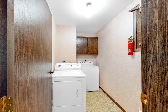 clothes washing area featuring cabinets and washing machine and dryer