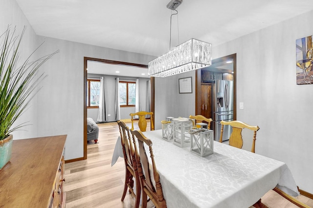 dining room featuring a notable chandelier and light wood-type flooring