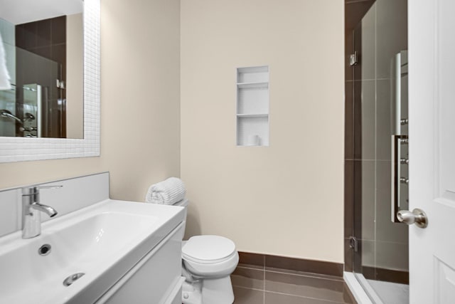 bathroom with tile patterned floors, toilet, a shower with shower door, and vanity