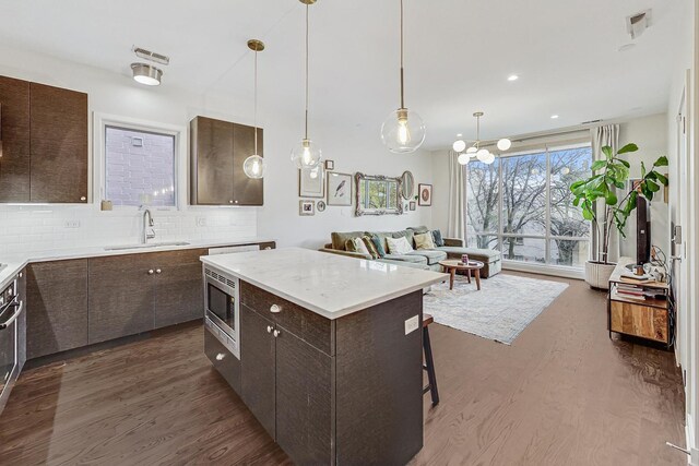 kitchen featuring sink, dark brown cabinets, and a center island