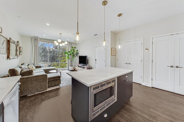 kitchen with hanging light fixtures, a center island, white dishwasher, dark hardwood / wood-style flooring, and stainless steel microwave