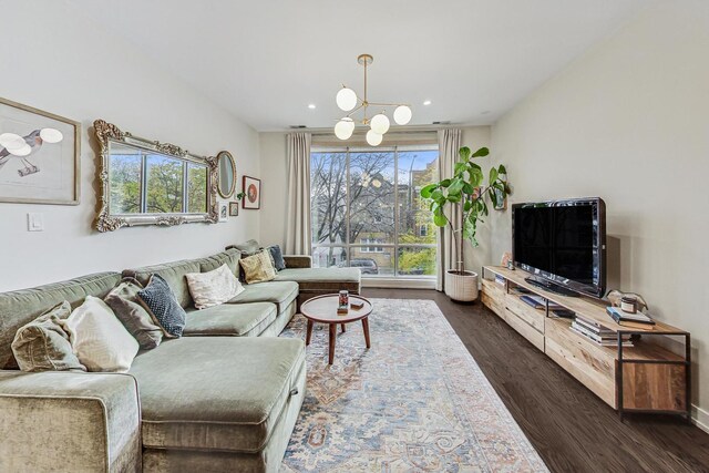 living room with a chandelier and dark wood-type flooring