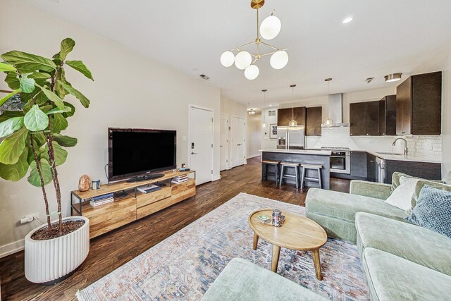 living room featuring an inviting chandelier, dark hardwood / wood-style flooring, and sink