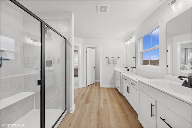 bathroom featuring walk in shower, wood-type flooring, and vanity