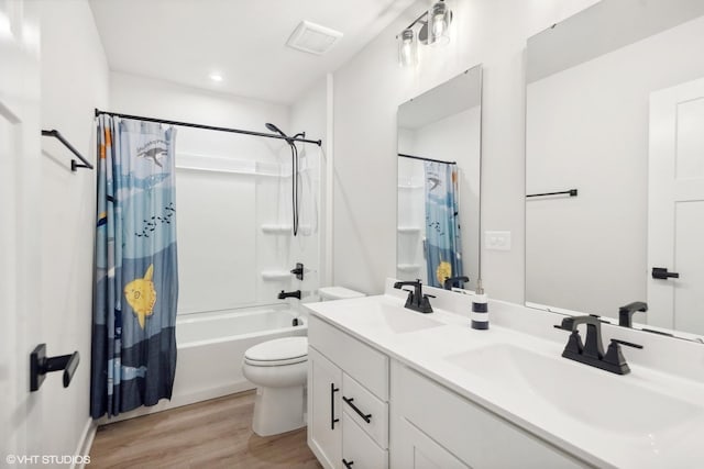 full bathroom with shower / tub combo, vanity, wood-type flooring, and toilet