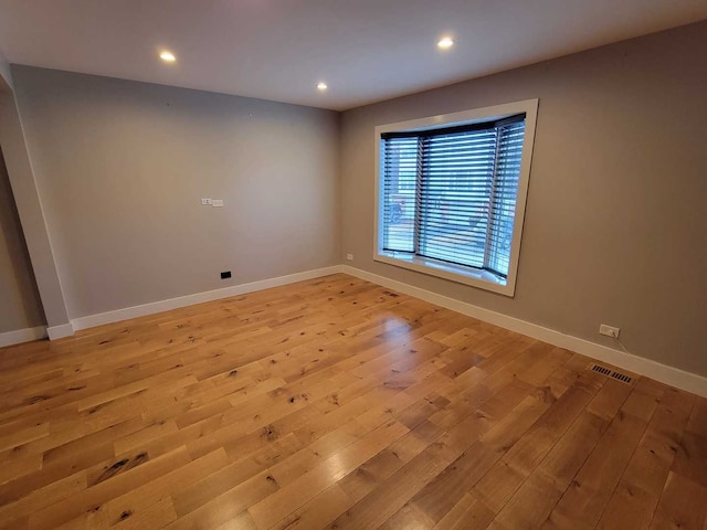 spare room featuring recessed lighting, light wood-type flooring, visible vents, and baseboards