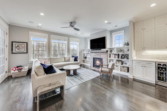 living room with dark hardwood / wood-style flooring, crown molding, ceiling fan, and wine cooler