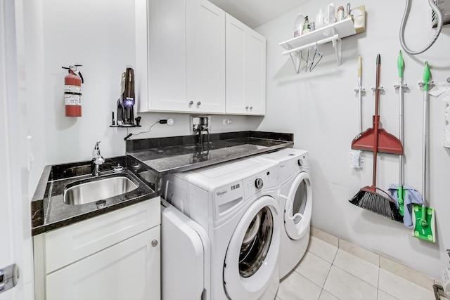 washroom with sink, cabinets, light tile patterned flooring, and washing machine and clothes dryer