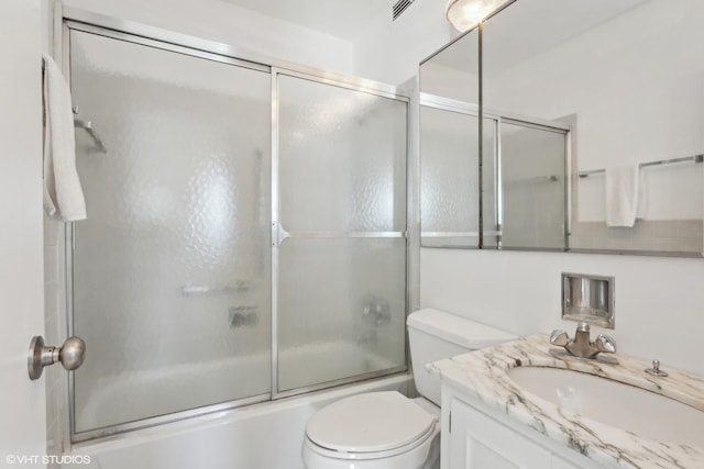 full bathroom with vanity, toilet, and bath / shower combo with glass door