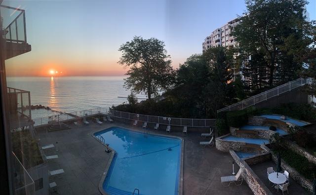 pool at dusk with a patio area and a water view