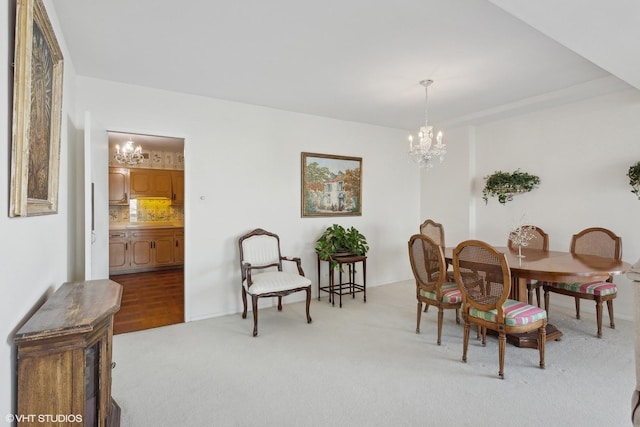 carpeted dining room with a notable chandelier