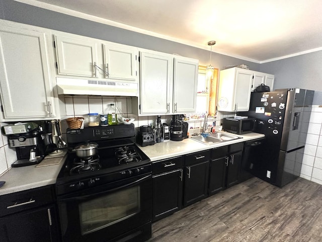 kitchen featuring wood-type flooring, black appliances, pendant lighting, sink, and white cabinetry