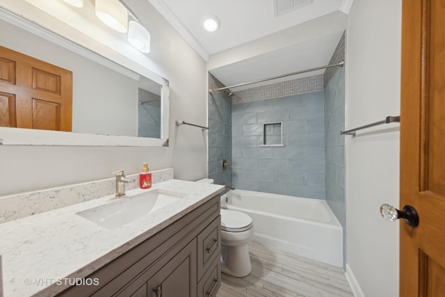 full bathroom with crown molding, hardwood / wood-style floors, tiled shower / bath combo, vanity, and toilet