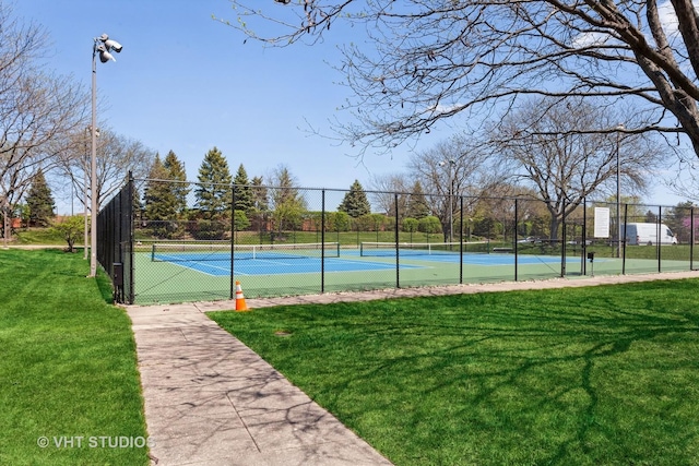 view of tennis court with a yard