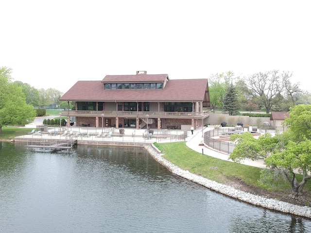 back of house featuring a water view and a patio