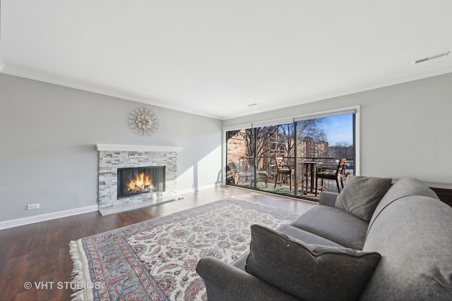 living room featuring crown molding, a fireplace, and dark hardwood / wood-style floors