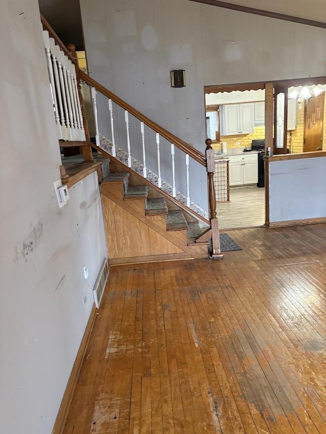 staircase featuring lofted ceiling and hardwood / wood-style flooring