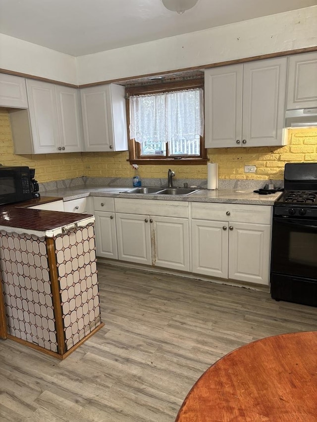 kitchen featuring white cabinetry, light hardwood / wood-style floors, sink, and black appliances