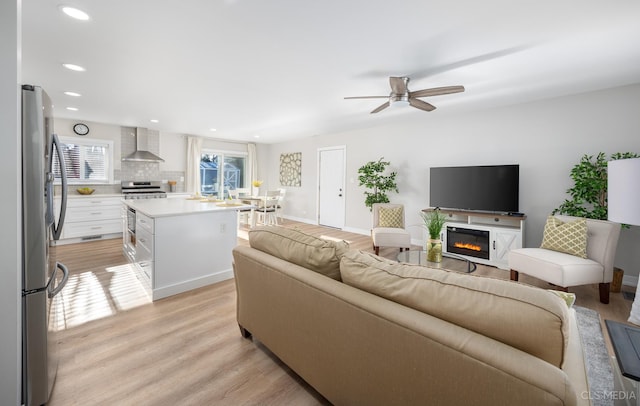 living room with light hardwood / wood-style floors and ceiling fan