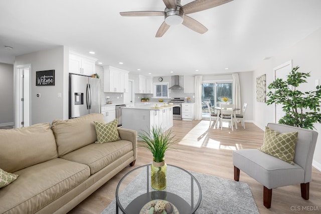 living room featuring ceiling fan and light hardwood / wood-style floors