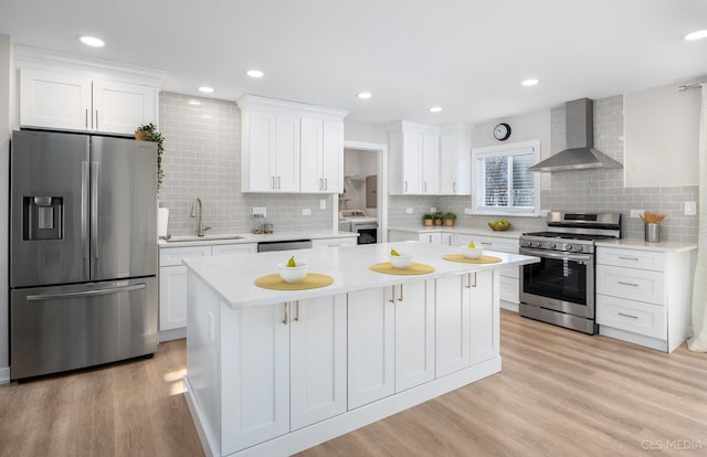 kitchen featuring white cabinets, sink, wall chimney exhaust hood, washer / dryer, and stainless steel appliances