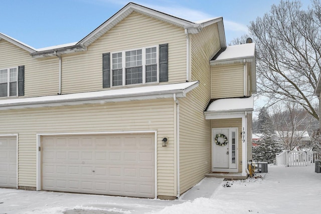 view of front of home with central AC and a garage